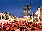 Belebte Abendstimmung auf der Reeperbahn in Hamburg mit Lichterketten, Straßencafés und tanzenden Türmen im Hintergrund