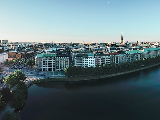 Panorama der Binnenalster bei Sonnenaufgang mit Blick auf Hamburgs Innenstadt und glitzerndem Wasser