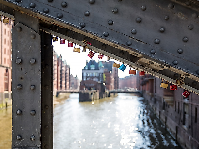 Liebesschlösser an Brücke in der Speicherstadt mit Blick auf das Wasserschloss in Hamburg