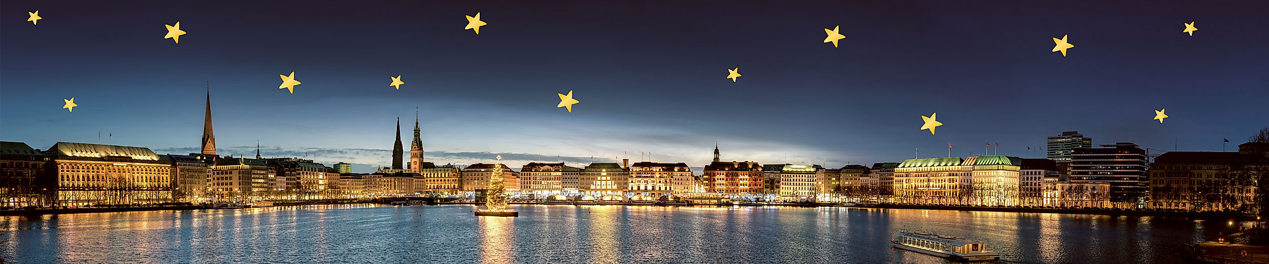 Beleuchteter Weihnachtsbaum auf der Binnenalster vor dem festlich erleuchteten Jungfernstieg bei Nacht.