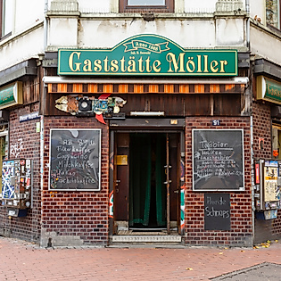 Fassade der Raucherkneipe ‘Möllers’ in Hamburg mit geöffneten Türen und beschrifteten Tafeln