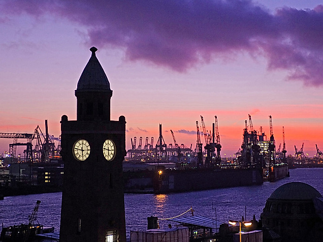 Abendstimmung am Hamburger Hafen mit beleuchtetem Pegelturm und Blick auf Kräne im letzten Tageslicht