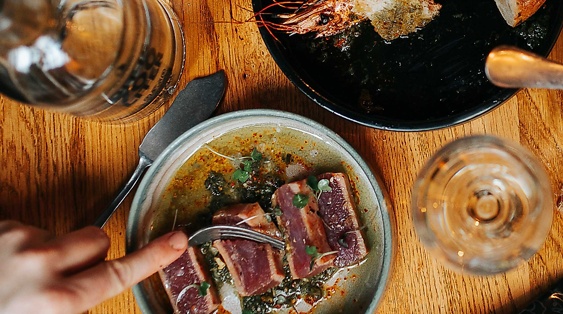 Meeresfrüchte, Brot und Wein auf rustikal gedecktem Tisch im Restaurant Pesca im Westfield Überseequartier