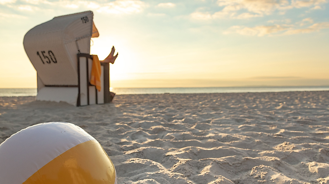 Strandkorb und Wasserball am Strand bei Sonnenuntergang – Ausflugsziel ab Hamburg