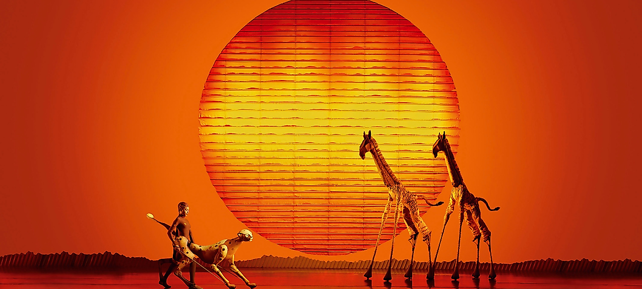 Szenenbild König der Löwen: Giraffen und Löwe bei Sonnenuntergang