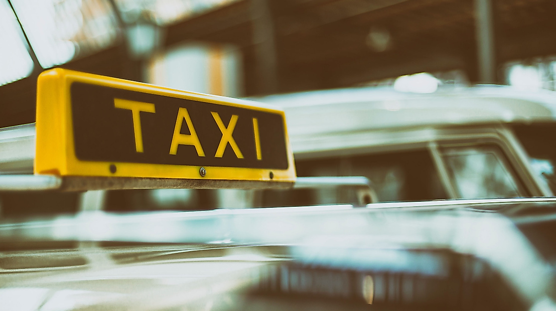 Gelbes Taxischild auf einem Auto, Symbolbild für barrierefreie Taximobilität in Hamburg.