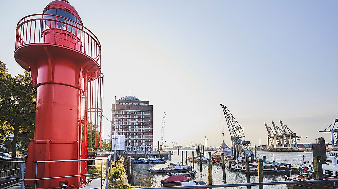 Roter Leuchtturm am Museumshafen Övelgönne mit Blick auf Elbe, Schiffe und Containerkräne im Abendlicht