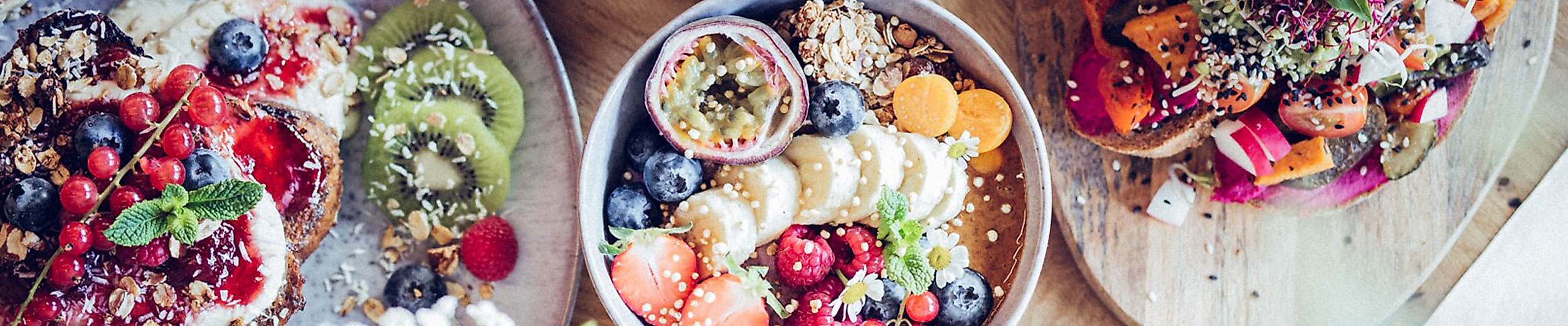 Bunte Auswahl an vegetarischen und veganen Speisen auf gedecktem Tisch in heller, moderner Umgebung