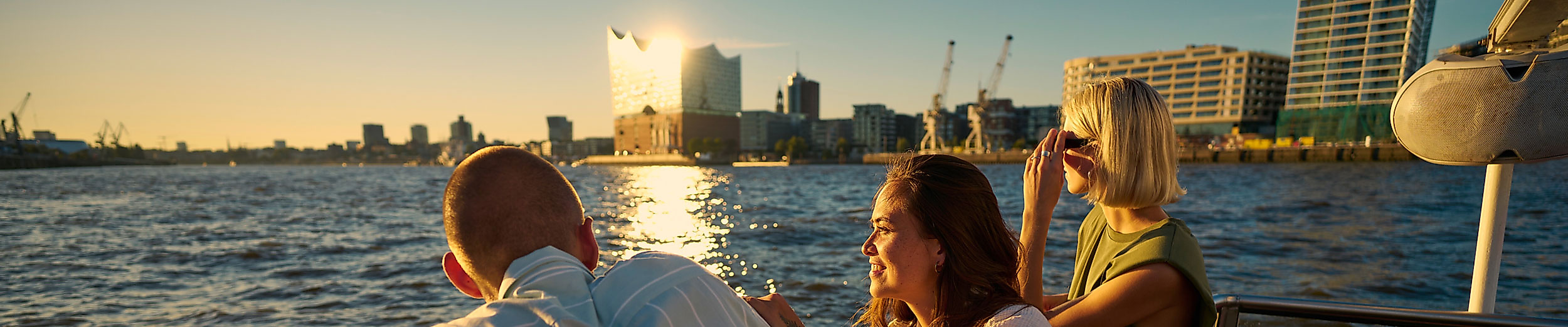 Barkassenfahrt bei Sonnenuntergang mit Blick auf die Elbphilharmonie und Hamburgs Skyline vom Wasser aus.