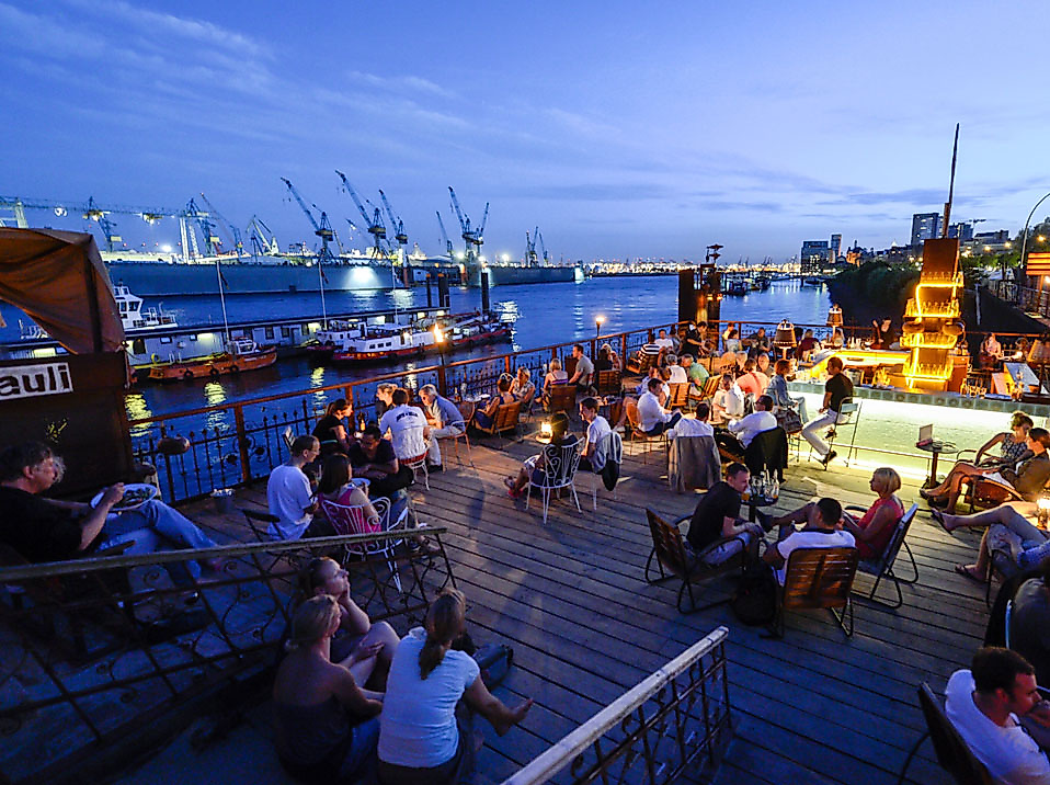 Abendliche Sommerstimmung im StrandPauli in Hamburg mit Blick auf den Hafen und entspannter Outdoor-Gastronomie.