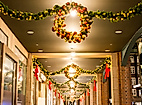 Festlich geschmückte Passage mit Lichterkränzen und Tannengirlanden in weihnachtlicher Abendstimmung