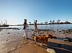 Ein junges Paar geht mit Hund an der Elbe spazieren.
