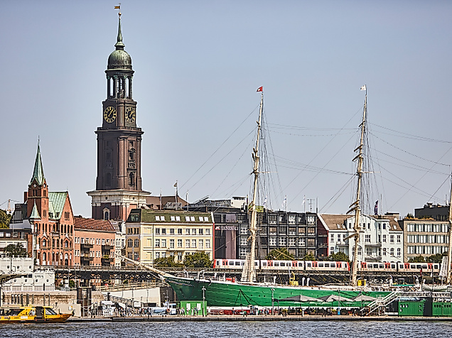 Blick vom Wasser auf den Hamburger Hafen mit Michel-Turm und Museumsschiffen im Vordergrund