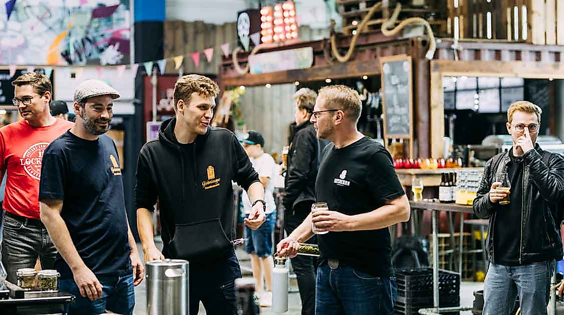 Mehrere Männer im Gespräch mit Biergläsern bei einer Verkostung auf der Hamburg Beer Week