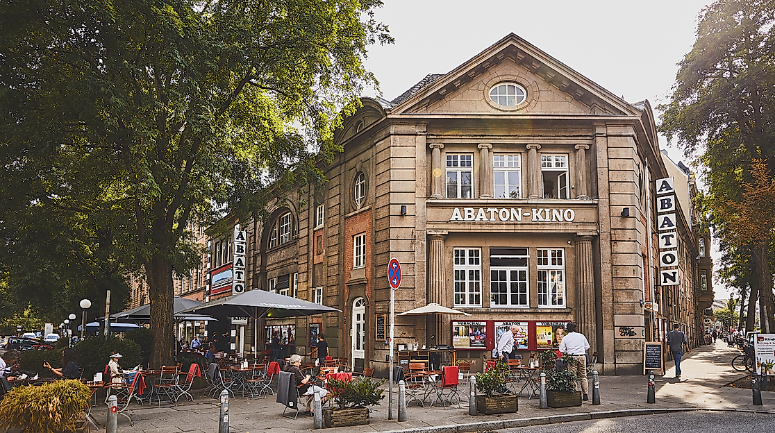 Außenansicht des Abaton-Kinos in Hamburg mit Cafébetrieb und Besuchenden vor historischer Fassade