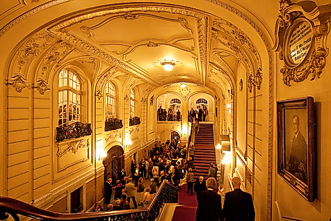 Festlich beleuchtetes Treppenhaus der Laeiszhalle mit stuckverzierter Decke und Publikum in Abendgarderobe