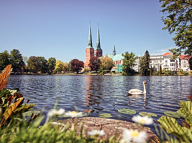 Blick über See auf den Dom zu Lübeck mit Zwillingstürmen bei klarem Himmel und Sommerstimmung