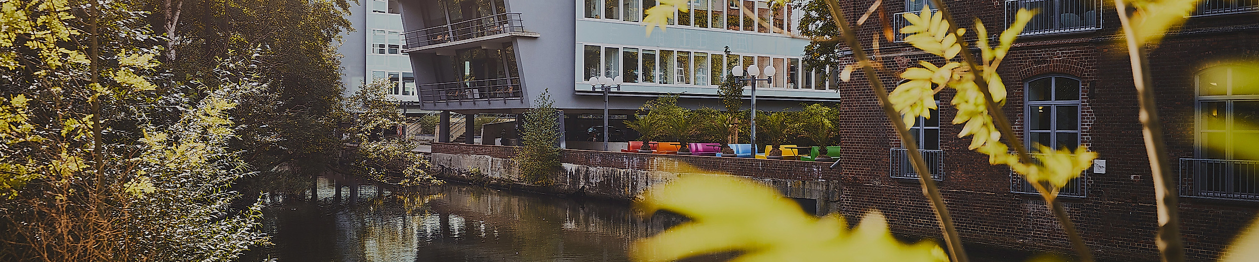 Rückseite des Archäologischen Museums Hamburg am Kaufhauskanal in Harburg, gerahmt von Bäumen und Herbstlaub
