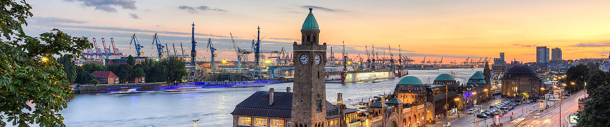 Landungsbrücken an der Elbe mit Hafen im Hintergrund in der Abenddämmerung