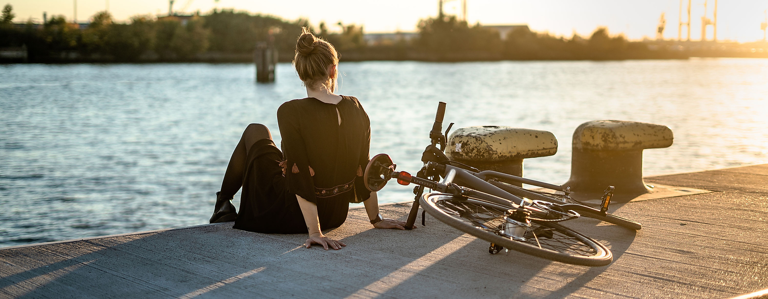 fahrrad_sonnenuntergang_hafen_landungsbruecken_frau_c-simon_adobestock_241398881