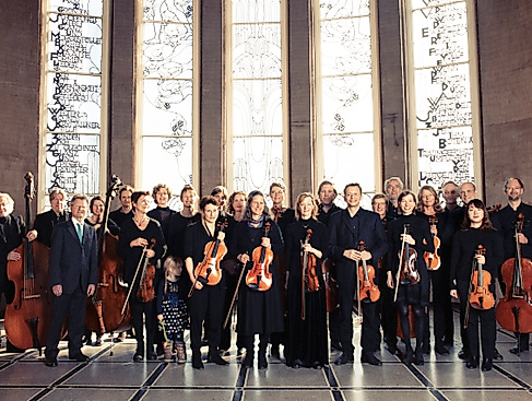 Orchesterfoto vor verzierten Fenstern