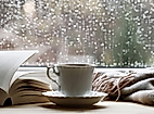 Gemütliche Tasse Tee vor verregneter Fensterscheibe