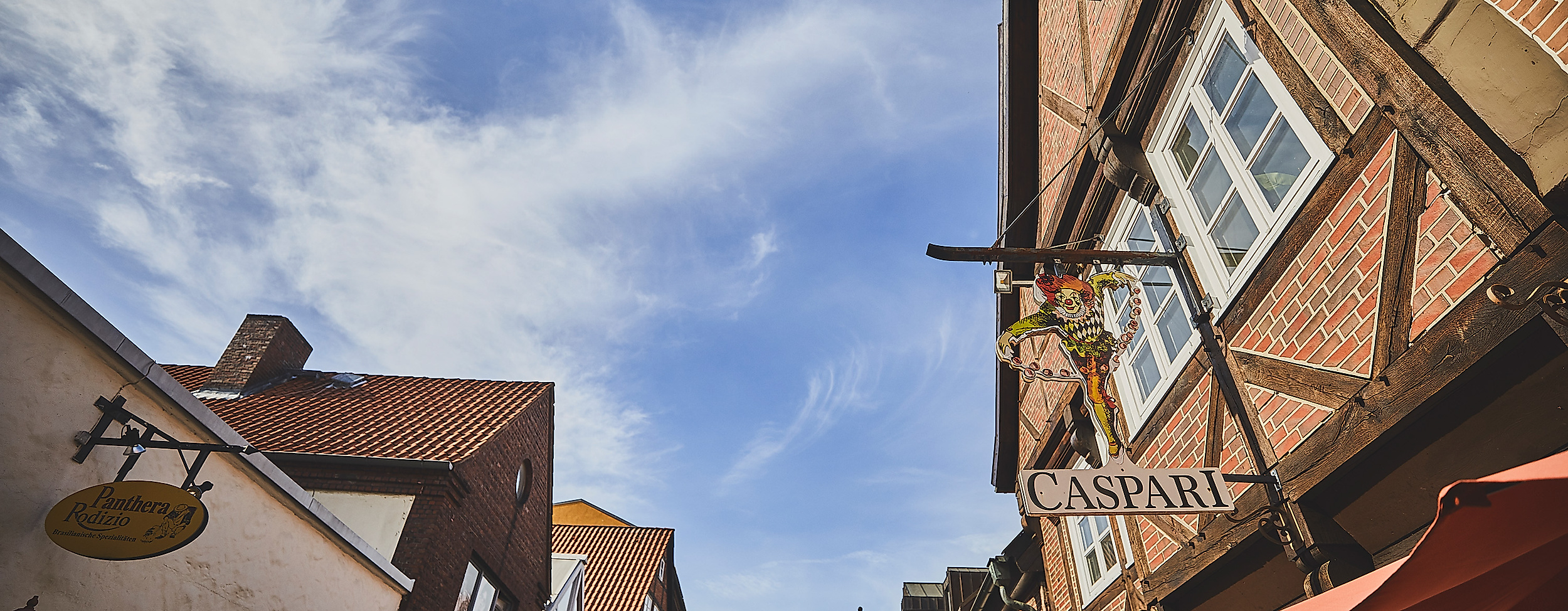 Blick auf historische Fassaden und Lichterketten in der Lämmertwiete in Hamburg-Harburg unter blauem Himmel
