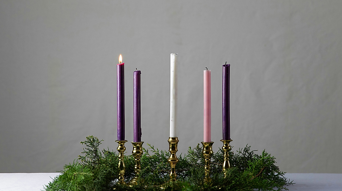 Adventskranz mit einer brennenden Kerze