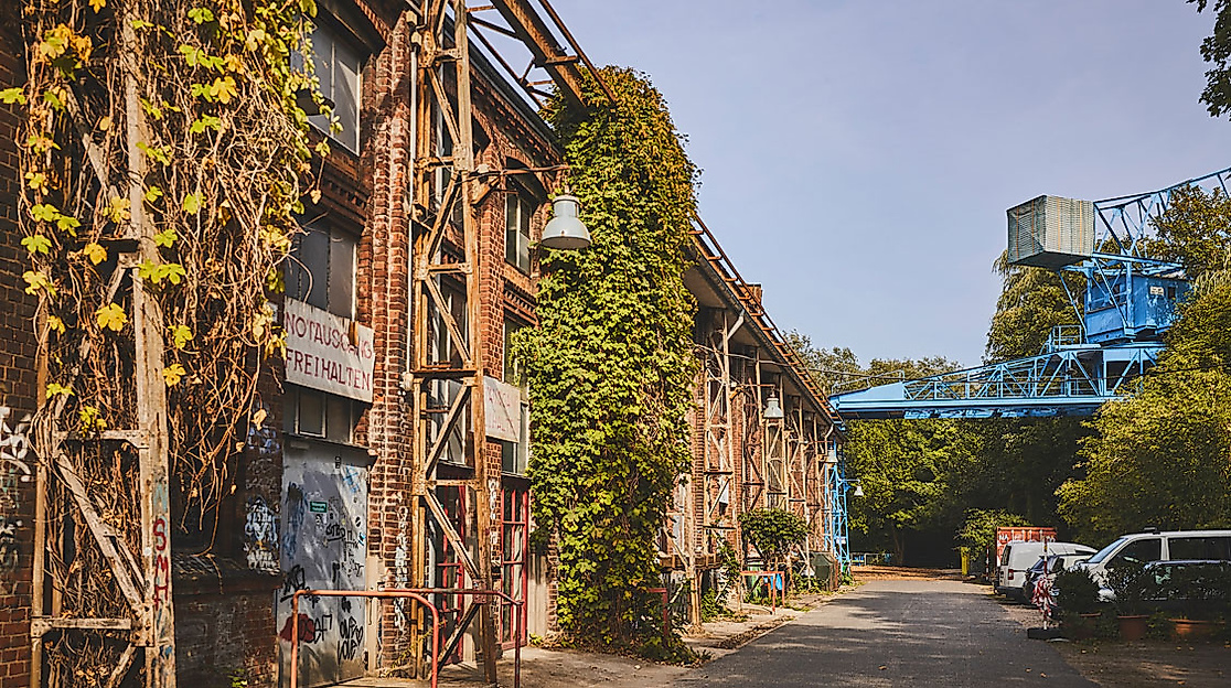 Backsteinfassade des Kampnagel-Geländes in Hamburg mit Industriekonstruktion und blauem Kran bei Tageslicht