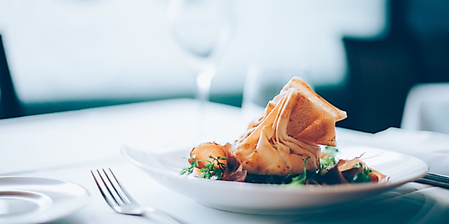 Gedämpfte asiatische Teigtaschen in Bambuskörbchen, serviert mit Dip und Stäbchen auf dunklem Untergrund