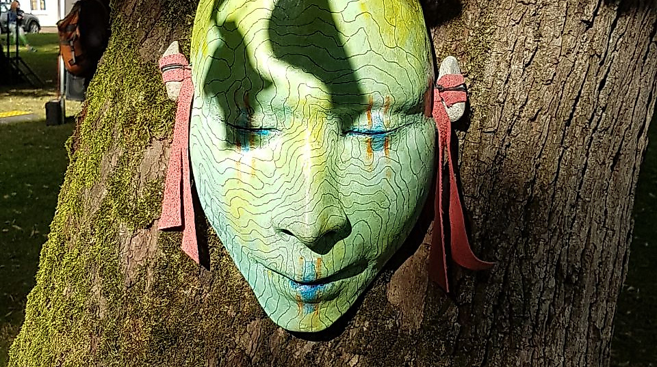 Grüne Maske am Baum