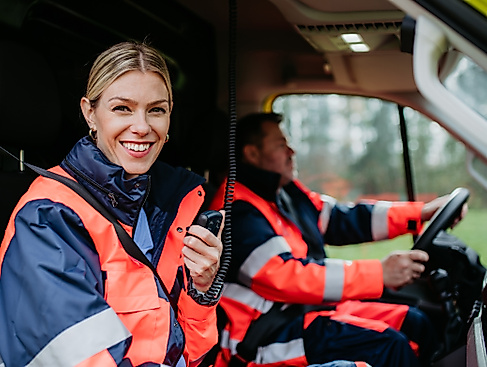 smiling-paramedic-woman-holding-radio-in-ambulance-2026-09-24-05-04-45-utc