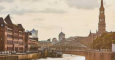Abendstimmung in der Hamburger Speicherstadt mit Blick auf Kanal, historische Gebäude und Kirchturm
