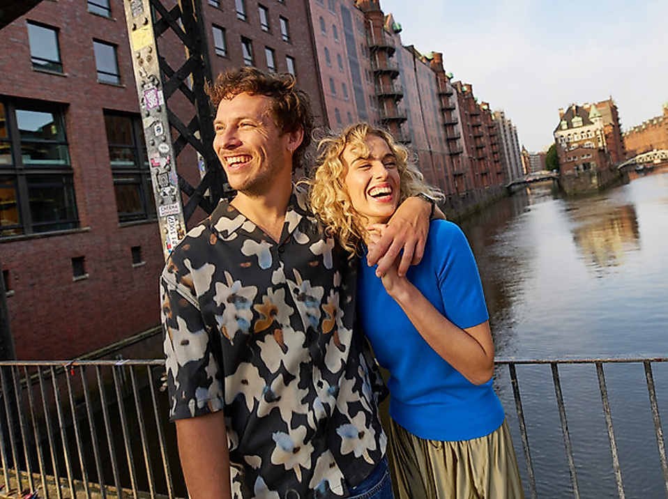 Paar lacht in die Kamera im Hintergrund sieht man das Wasserschloss