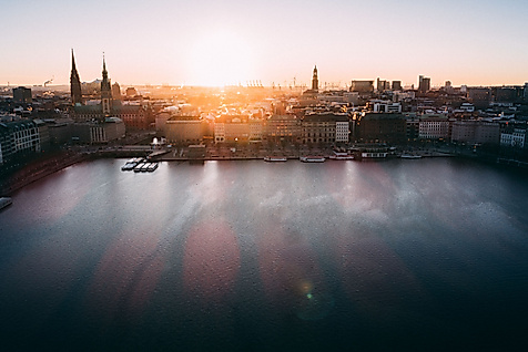 Panoramablick auf die Binnenalster bei Sonnenuntergang mit Kirchtürmen der Hamburger Altstadt.