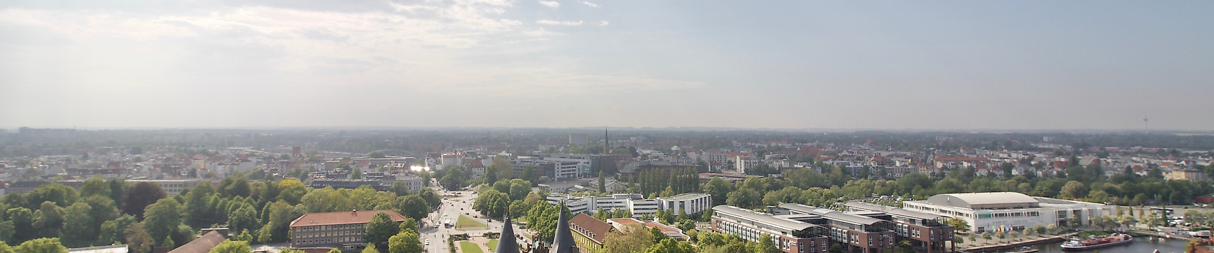 Panoramablick über Lübecks Altstadt mit Holstentor und roten Giebeldächern unter leicht bewölktem Himmel