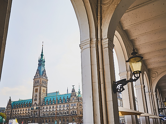 Blick durch die Alsterarkaden auf das Hamburger Rathaus mit markantem Turm