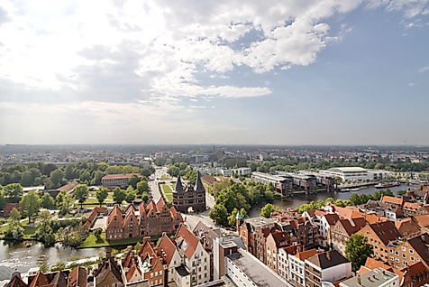 Panoramablick über Lübecks Altstadt mit Holstentor und roten Giebeldächern unter leicht bewölktem Himmel