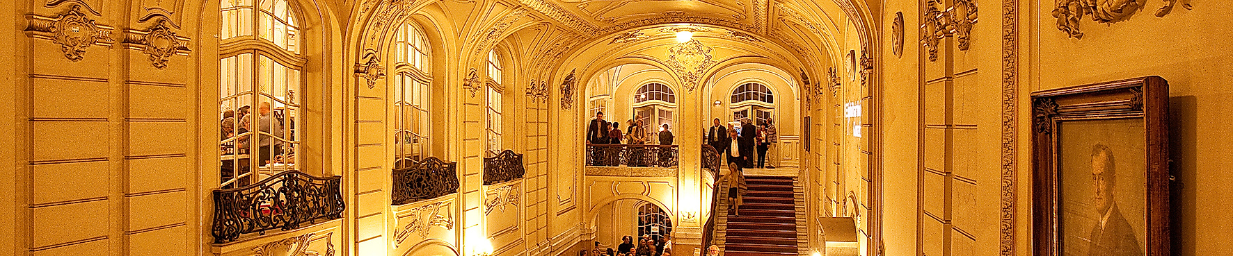 Festlich beleuchtetes Treppenhaus der Laeiszhalle mit stuckverzierter Decke und Publikum in Abendgarderobe
