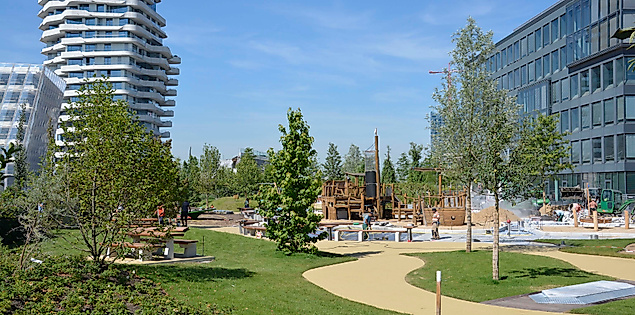 Lohsepark in der HafenCity Hamburg mit Spielplatz, Wiese und moderner Architektur bei Sonnenschein