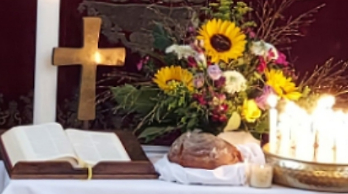 Altar mit Brot, Blumen, Kerze, Kreuz, Bibel