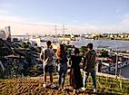 Vier Freunde schauen auf den Hamburger Hafen bei Sonnenaufgang
