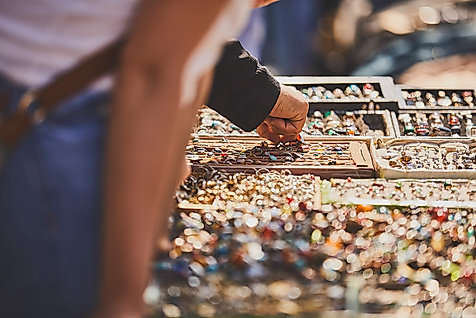 Zwei Personen stöbern an einem Schmuckstand mit bunten Ringen auf dem Flohmarkt Flohschanze in Hamburg