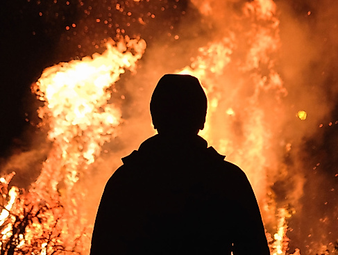 Silhouette vor loderndem Feuer