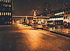 Christmas lights reflecting on wet cobblestones at night in a festively lit Hamburg street