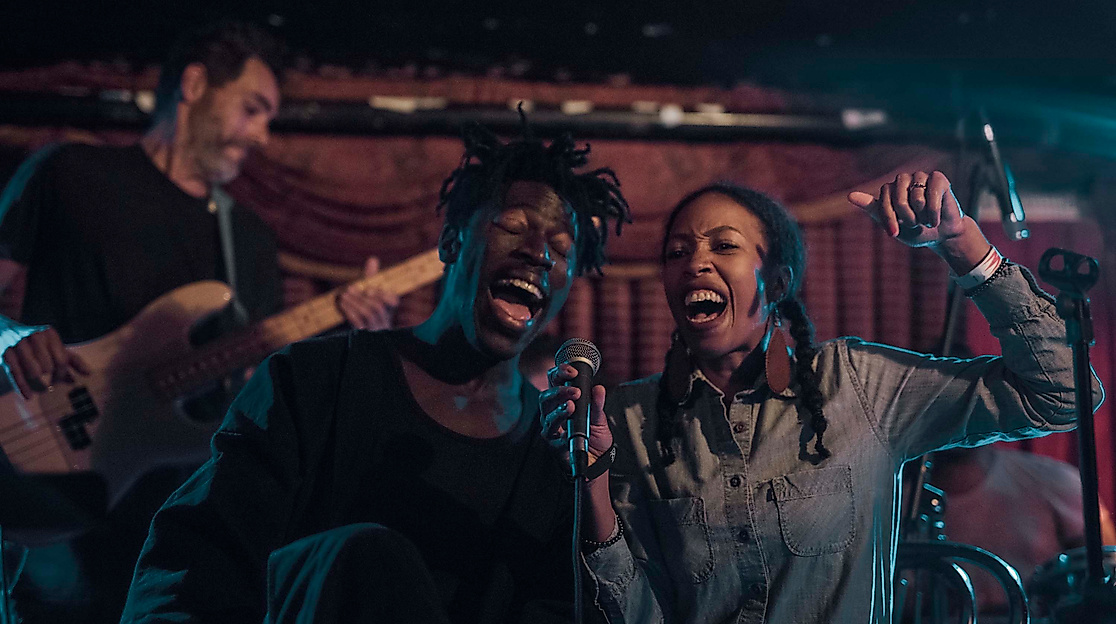 Jazzband mit zwei Sänger:innen auf stimmungsvoll beleuchteter Bühne, Live-Auftritt beim Jazzfestival