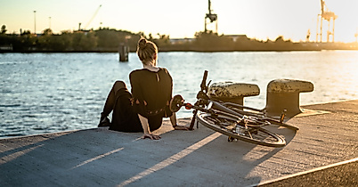 fahrrad_sonnenuntergang_hafen_landungsbruecken_frau_c-simon_adobestock_241398881