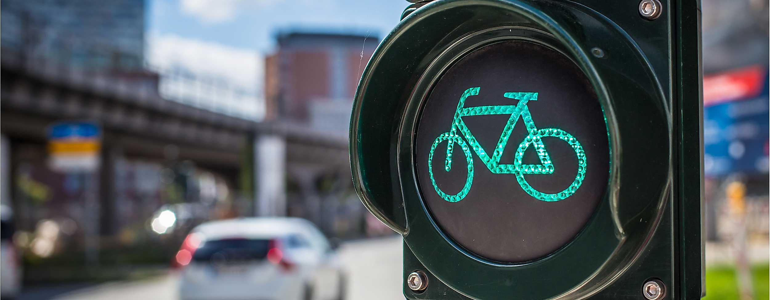 Grüne Fahrradampel vor Straßenverkehr und moderner Stadtkulisse in Hamburg.