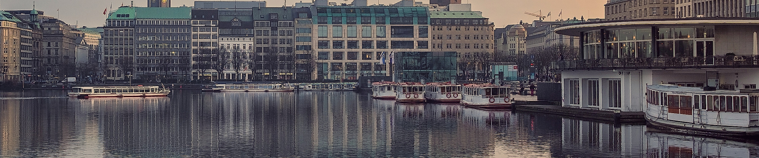Abendstimmung an der Binnenalster mit Stadtspiegelung im Wasser und Blick auf historische Gebäude