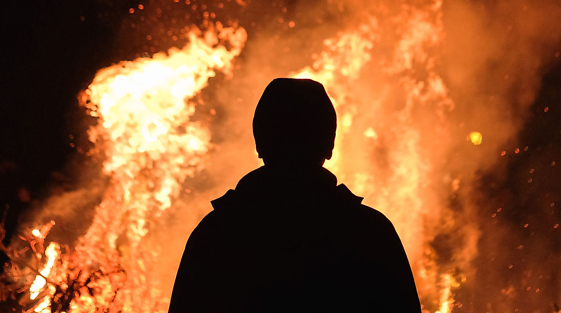 Silhouette vor loderndem Feuer